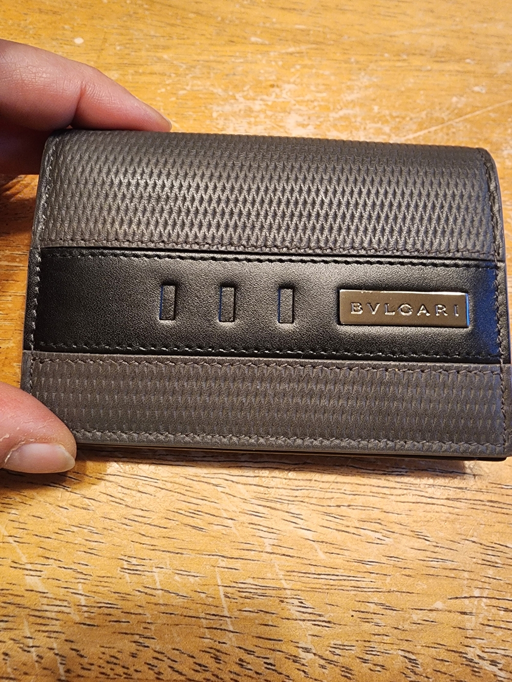 BVLGARI business card case is crafted from dark leather textured pattern